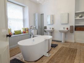A bathroom with a bathtub and sinks at 5 Porkington Terrace Barmouth