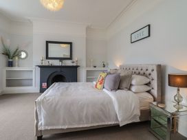 A bedroom with a bed and a fireplace at 5 Porkington Terrace in Barmouth