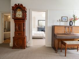 A living room with a grandfather clock and a piano at 5 Porkington Terrace in Barmouth