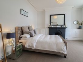 A bedroom with a bed and a mirror at 5 Porkington Terrace in Barmouth