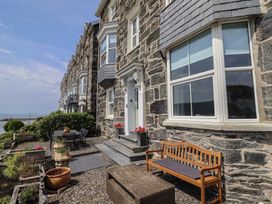 An exterior view of a building with a front door and outdoor seating at 5 Porkington Terrace in Barmouth
