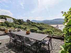 A garden with a table and chairs overlooking the sea at 5 Porkington Terrace Barmouth