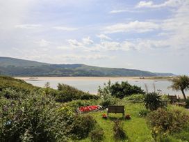 A garden with flowers and a view of the water at 5 Porkington Terrace in Barmouth
