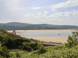 A river with sand and a bridge near mountains at 5 Porkington Terrace Barmouth