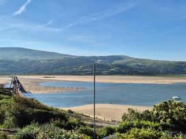 A view of mountains and beach with a bridge at 5 Porkington Terrace Barmouth