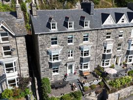 A stone house with patio furniture and garden at 5 Porkington Terrace in Barmouth