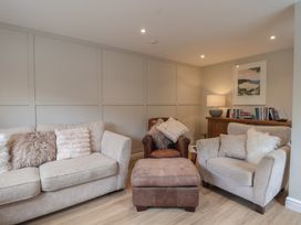 A living room with a sofa and armchairs at Wrens Nest in Slapton