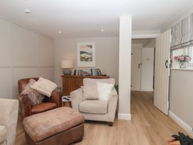 A living room with an armchair and a sofa at Wrens Nest in Slapton