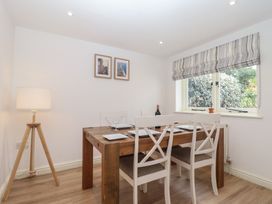 A dining room with a table set for meals at Wrens Nest in Slapton