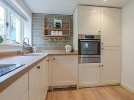 A kitchen with cabinets, sink, oven, and kettle at Wrens Nest, Slapton