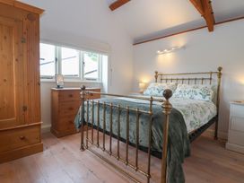 A bedroom with a bed and wardrobe at Wrens Nest in Slapton