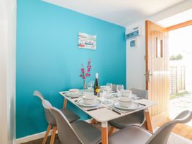 A dining area with a set table on a white table against a blue wall at Broadsands in Paignton