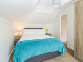 A bedroom with a double bed with white bedding and a blue throw blanket at Broadsands in Paignton