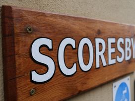 A wooden sign displaying the word Scoresby at Scoresby Cottage @ Summerfield Farm, Hawsker