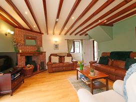A living room with two sofas, a coffee table, and a television at Scoresby Cottage @ Summerfield Farm, Hawsker