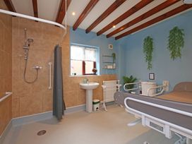 A bathroom with a shower and a sink at Scoresby Cottage @ Summerfield Farm Hawsker