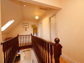 A hallway with a staircase and doors at Scoresby Cottage @ Summerfield Farm, Hawsker
