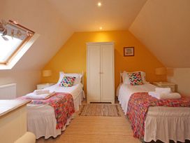 A bedroom with twin beds and a wardrobe at Scoresby Cottage @ Summerfield Farm, Hawsker