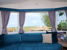 A living room with a couch and window view at Abbey View @ Summerfield Farm in Hawsker