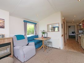 A living room with a sofa and table at Abbey View @ Summerfield Farm in Hawsker