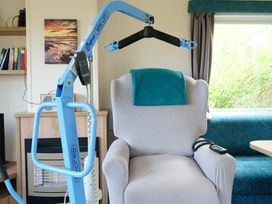 A living room with a hoist and an armchair at Abbey View @ Summerfield Farm, Hawsker