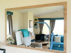 A living room with a chair and television at Abbey View @ Summerfield Farm in Hawsker