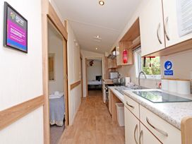 A kitchen with a sink and stove at Abbey View @ Summerfield Farm Hawsker