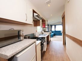 A kitchen with appliances and a view at Abbey View @ Summerfield Farm, Hawsker