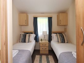 A bedroom with twin beds and a bedside table at Abbey View @ Summerfield Farm, Hawsker