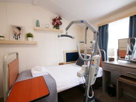 A bedroom with a bed and support lifting device at Abbey View @ Summerfield Farm in Hawsker