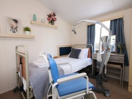 A bedroom with a bed and a desk at Abbey View @ Summerfield Farm in Hawsker