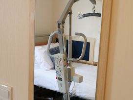 A bedroom featuring a bed and a patient lift at Abbey View @ Summerfield Farm, Hawsker
