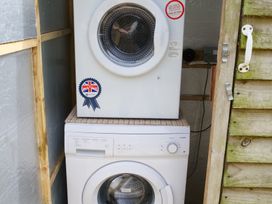 A washing machine and tumble dryer in a laundry area at Abbey View @ Summerfield Farm, Hawsker