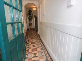 A hallway with an indoor plant and staircase at Still Waters in Swanage