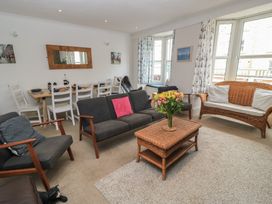 A living room with a coffee table and dining area at Still Waters in Swanage