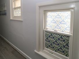 A corridor with two windows featuring decorative glass at Still Waters in Swanage