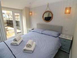 A bedroom with a bed and side table at Still Waters in Swanage