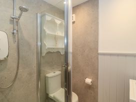 A bathroom with a shower and toilet at Still Waters in Swanage