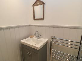 A bathroom with a sink and mirror at Still Waters in Swanage