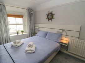 A bedroom with a bed and a window at Still Waters in Swanage