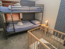 A bedroom with bunk bed and crib at Still Waters in Swanage