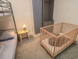 A bedroom with a bunk bed and a cot at Still Waters in Swanage