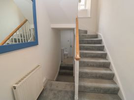 A staircase leading to upper floor with a toilet visible at Still Waters in Swanage