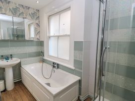 A bathroom featuring a bathtub, sink, and shower at Still Waters in Swanage
