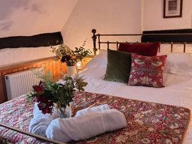 A bedroom with a bed and flowers on the bed at Runnymede in Tewkesbury