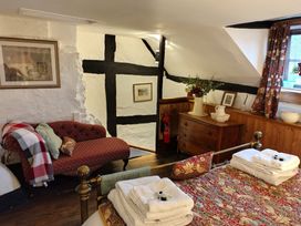 A bedroom with a sofa and a bed at Runnymede in Tewkesbury