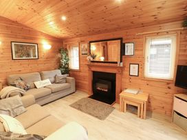 A living room with a sofa and a fireplace at The Fold, Number 28, Burnside Park near Keswick