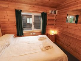 A bedroom with a bed and shelves at The Fold Number 28, Burnside Park near Keswick