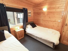 A bedroom with two beds and a nightstand at The Fold Number 28, Burnside Park near Keswick