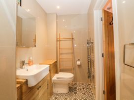 A bathroom with a sink cabinet toilet wooden ladder towel rack and patterned floor tiles at Apartment 4 10 Somers Court in Paignton